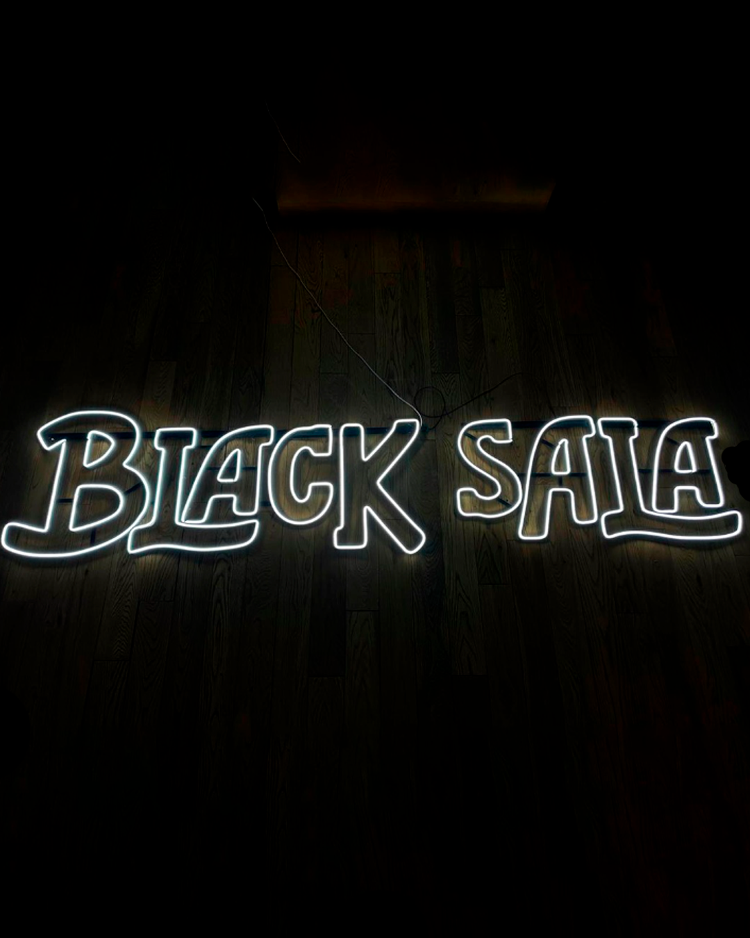 Cartel de neón rosa brillante que dice 'BAR' para un local nocturno.